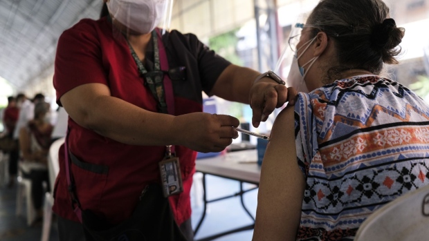 A health worker administers a second dose of the Sinovac Biotech Ltd. Covid-19 vaccine at a health clinic in Quezon City, Metro Manila, the Philippines, on Tuesday, May 11, 2021. The Philippines’ economy is struggling to gain momentum as elevated numbers of Covid cases hamper reopening efforts and destroy jobs.
