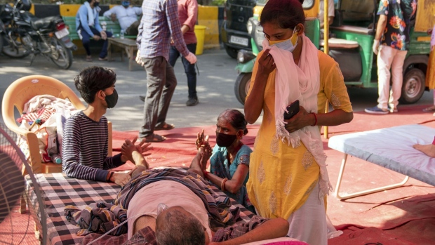 Relatives attend to a Covid-19 patient receiving oxygen in Uttar Pradesh, India, on May 11. Photographer: Sumit Dayal/Bloomberg