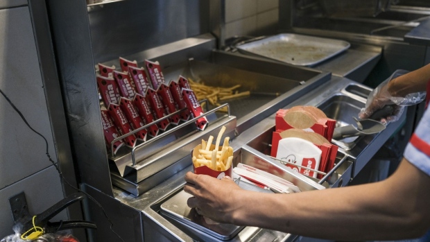 A service assistant prepares a customer's take-out order at the Jollibee Foods Corp. restaurant in Taguig City, Manila, the Philippines, on Saturday, March 13, 2021. Jollibee will boost capital spending by a fifth to open 450 new stores mostly overseas, as the Philippines' largest restaurant operator foresees a return to profit this year following its first annual loss in nearly three decades. Photographer: Veejay Villafranca/Bloomberg
