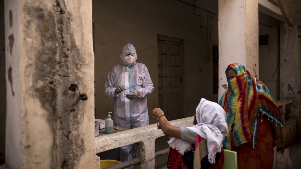A health worker wearing prepares swab to be taken at a Covid-19 testing site set up in the employment exchange office in Agra, Uttar Pradesh, India, on Monday, May 3, 2021. India's fierce second wave has overwhelmed the nation's underfunded health system, with infections topping 400,000 cases in a day and hospitals running out of beds, oxygen and medical supplies.