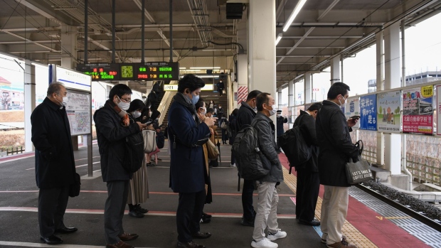 Commuters wait for a train at the platform of Chiba Newtown Chuo station in Inzai. Chiba Prefecture, Japan, on Monday, March 8, 2020. Japanese Prime Minister Yoshihide Suga extended by two weeks a virus state of emergency for the Tokyo region that has expired on Sunday, trying to maintain a declining trend in infections as the country looks to host the Olympics in about four months. Photographer: Noriko Hayashi/Bloomberg