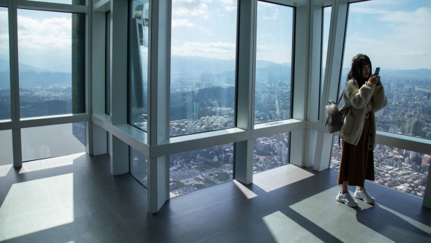 A woman takes a photograph on the observation deck of the Taipei 101 building in Taipei, Taiwan on Sunday, Jan. 5, 2020. Investor sentiment toward Taiwan has rarely been this good, with only days to go before its first presidential election in four years. Photographer: Betsy Joles/Bloomberg