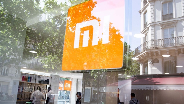 A logo sits in the window of a Xiaomi Corp. store in Paris, France, on Friday, May 25, 2018. Chinese smartphone maker Xiaomi opened it's first store in Paris and plans for more shops in France, Spain and Italy, testing the appetite of consumers in developed markets as its executives consider a U.S. expansion. Photographer: Christophe Morin/Bloomberg