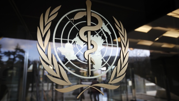The World Health Organization (WHO) emblem sits on a glass entrance door at the WHO headquarters in Geneva, Switzerland, on Tuesday, Feb. 18, 2020. So far, 73,424 people have been infected with COVID-19 and 1,873 have died around the world, the vast majority of them in China's Hubei province.
