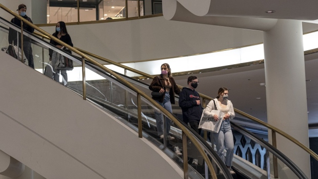 Shoppers wearing protective masks ride an escalator inside the Westfield San Francisco Centre shopping mall in San Francisco, California, U.S., on Tuesday, March 9, 2021. San Francisco Mayor London Breed said indoor dining, movie theaters and gyms can reopen on a limited basis after California moved the region to a less-restrictive tier.