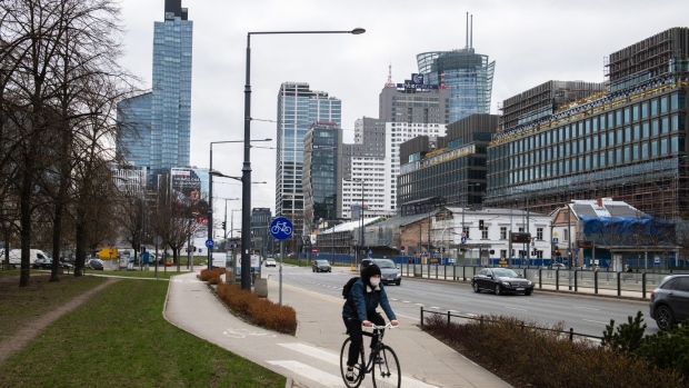 A cyclist uses a cycle lane near offices and skyscrapers in the financial district in Warsaw, Poland, on Tuesday, April 6, 2021. Poland's Central Bank’s Monetary Policy Council meets on Wednesday to set policy after the economy was hit with new restrictions in March to stop the spread of the Coronavirus pandemic.