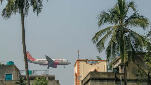 An Air India Ltd. aircraft prepares to land at Netaji Subhas Chandra Bose International Airport in Kolkata, India, on Sunday, Dec. 6, 2020. Covid-19 has put the sprawling Tata Sons Ltd., which owns a 51% stake in each of AirAsia India and Vistara, at a crossroads. Either go big, by buying state-run Air India for example, or bow out before spilling more red ink.