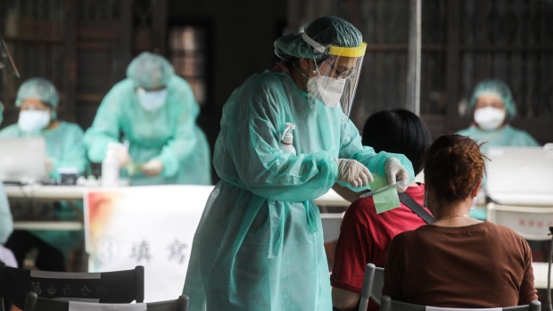 A health worker checks personal information at a temporary Covid-19 rapid testing center in the Wanhua area of Taipei, Taiwan, on Saturday, May 15, 2021. Taiwan imposed restrictions on gatherings and ordered entertainment businesses to shutter operations as it raised the alert level in its capital to battle a surge in local Covid-19 infections.