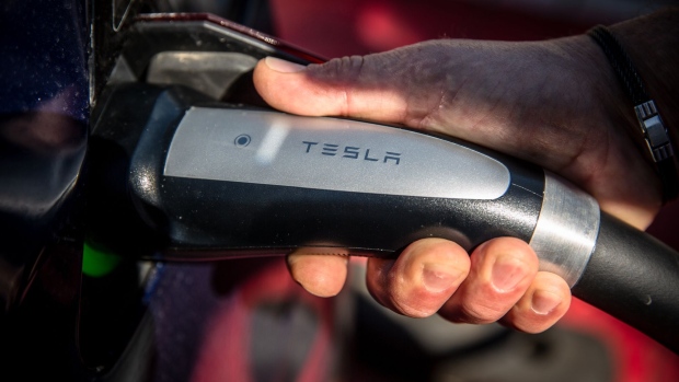 A driver inserts a charging plug into a Tesla Inc. electric vehicle at a Supercharger station in Girona, Spain, on Wednesday, July 10, 2019. Tesla is poised to increase production at its California car plant and is back in hiring mode, according to an internal email sent days after the company wrapped up a record quarter of deliveries. Photographer: Angel Garcia/Bloomberg