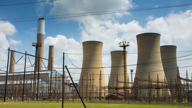 An electrical substation near cooling towers at the Komati coal-fired power station, operated by Eskom Holdings SOC Ltd., in Mpumalanga, South Africa, on Tuesday, Jan. 12, 2021. In South Africa, for decades almost all the electricity needed to power Africa’s most industrialized economy has been produced by a fleet of aging coal-fired plants constructed alongside the mines to the east of Johannesburg. Photographer: Waldo Swiegers/Bloomberg