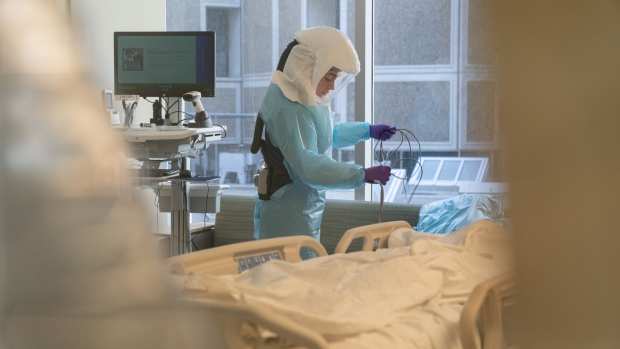 A hospital worker wearing a 3M Co. powered air purifying respirator (PAPR) hood disinfects a room after a patient departure at the Covid-19 Intensive Care Unit (ICU) of Sharp Memorial Hospital in San Diego, California, U.S., on Thursday, Jan. 28, 2021. California reported fewer new cases and fatalities than its 14-day rolling average, according to the health department's website.