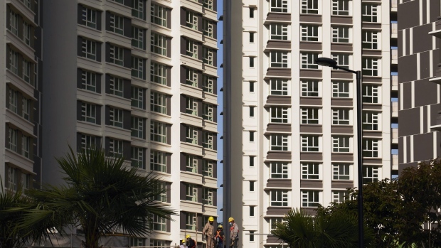 Workers on a construction site at the SkyOasis@Dawson, a Housing & Development Board (HDB) public housing estate, in Singapore, on Tuesday, April 13, 2021. Singapore’s central bank kept key policy settings unchanged as the city-state sees a brighter economic rebound amid a firming global recovery. The decision was announced at the same time as government data showing gross domestic product in the first quarter grew 0.2% from a year ago, after falling 2.4% in the previous three months. Photographer: Lauryn Ishak/Bloomberg