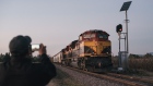 A person uses a mobile device to take photographs of a Kansas City Southern freight train halted by a teachers' union strike near the town of Maravatio, Michoacan state, Mexico, on Tuesday, Jan. 29, 2019. Teachers' protests in the central state of Michoacan in Mexico have virtually detained all shipping by railroad in some parts of the country. Eleven days of protests have led to two hundred halted trains, Ferrocarril Mexicano SA spokeswoman Lourdes Aranda said.