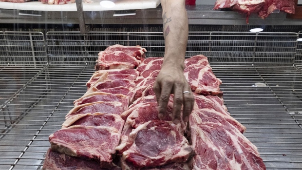 A worker arranges cuts of beef at a butcher's shop in Buenos Aires, Argentina, on Wednesday, Feb. 5, 2020. Argentina's Production Ministry is looking to add more cuts of beef to a price-control system in a bid to make red meat more affordable amid rampant inflation, according to a ministerial official. Photographer: Erica Canepa/Bloomberg