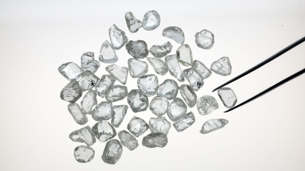 An employee inspects unpolished diamonds in the U.K. Photographer: Simon Dawson/Bloomberg