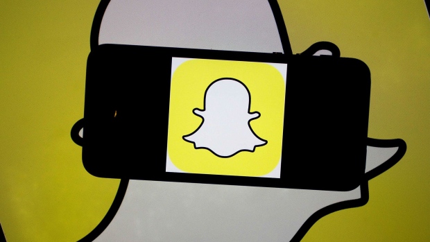 The Snapchat Inc. logo is displayed for a photograph on an Apple Inc. iPhone 5s and laptop computer in Washington, D.C., U.S., on Wednesday, Feb. 18, 2015. Snapchat Inc. is raising money that could value the company at as much as $19 billion. Photographer: Andrew Harrer/Bloomberg