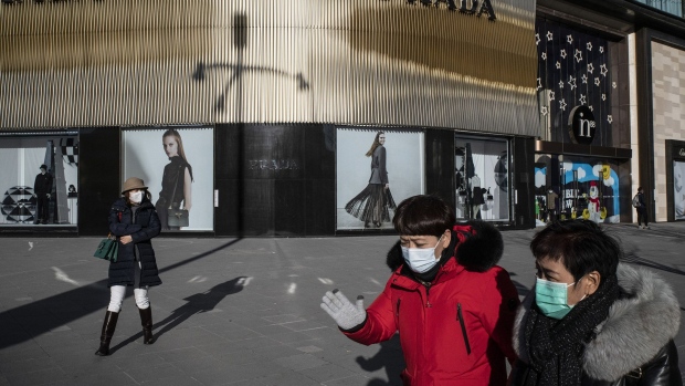 Pedestrians walk past a Prada SpA store in the Wangfujing shopping area of Beijing, China, on Monday, Dec. 7, 2020.