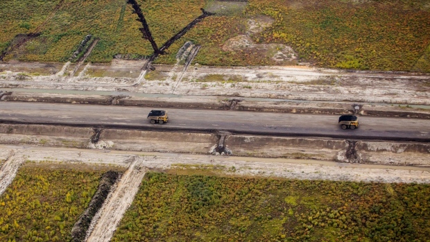 Heavy hauler trucks drive through the Albian Sands Energy Inc. Muskeg River mine in this aerial photograph taken above the Athabasca oil sands near Fort McMurray, Alberta, Canada, on Monday, Sept. 10, 2018.