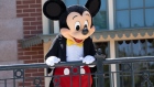 A performer dressed as Mickey Mouse entertains guests during the reopening of the Disneyland theme park in Anaheim, California, U.S., on Friday, April 30, 2021. Walt Disney Co.’s original Disneyland resort in California is sold out for weekends through May, an indication of pent-up demand for leisure activities as the pandemic eases in the nation’s most-populous state. Photographer: Bing Guan/Bloomberg