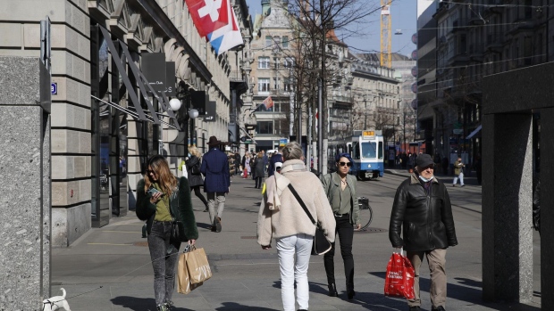 Shoppers walk along the Bahnhofstrasse in Zurich, Switzerland, on Monday, March 1, 2021. Switzerland has allowed non-essential shops, museums and outdoor sporting facilities to reopen, the first of several steps to unwind social distancing restrictions to contain the pandemic.