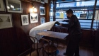 A worker puts down a table cloth at a restaurant in San Francisco. Photographer: David Paul Morris/Bloomberg