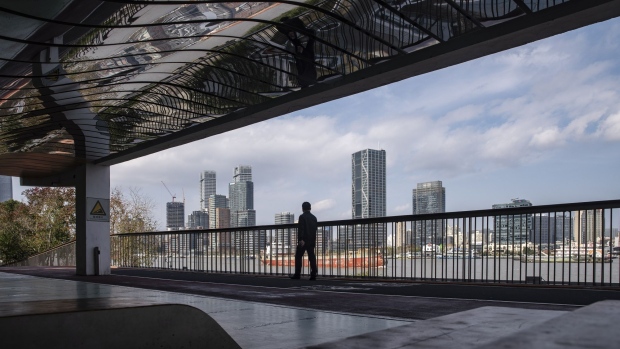 A pedestrian walks on a riverside path near the Lujiazui financial district in Shanghai, China, on Tuesday, Dec. 1, 2020. China unexpectedly added medium-term funding to the financial system on Monday, as the central bank sought to ease liquidity tightness in the final weeks of the year. Photographer: Qilai Shen/Bloomberg