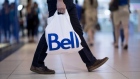 A customer holds a Bell Canada shopping bag outside a store in Toronto, Ont.