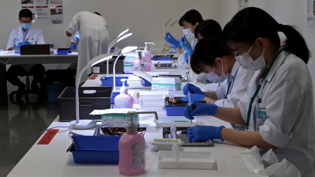 Healthcare workers prepare doses of the Pfizer-BioNTech Covid-19 vaccine at an inoculation site at Noevir Stadium Kobe in Kobe, Japan, on Tuesday, June 1, 2021. After some false starts, Japan’s much-delayed vaccine rollout is quietly picking up steam, now administering between 400,000 and 500,000 doses a day. Photographer: Buddhika Weerasinghe/Bloomberg