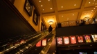 A moviegoer rides on an escalator at an AMC movie theater in New York, U.S., on Friday, March 5, 2021. The struggling U.S. box office is expected to rebound this weekend, when theaters in New York City, the second-largest U.S. movie market, reopen after a yearlong hiatus.
