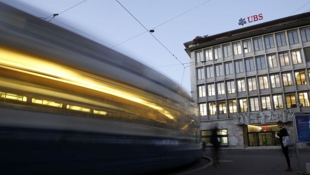 Trams pass by the UBS Group AG headquarters in Zurich, Switzerland, on Monday, Oct. 14, 2019. The spying scandal roiling Credit Suisse Group AG has also created a big headache at UBS a stone's throw away in Zurich: What to do about its star hire Iqbal Khan. Photographer: Stefan Wermuth/Bloomberg