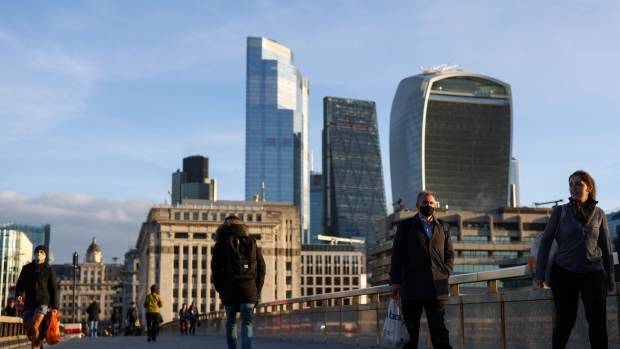 Commuters cross London Bridge in view of skyscrapers in the City of London skyline in London, U.K., on Thursday, Oct. 15, 2020. London is on course for an imminent tightening of coronavirus restrictions, as cases continue to rise in Britain and its response fragments. Photographer: Bloomberg/Bloomberg