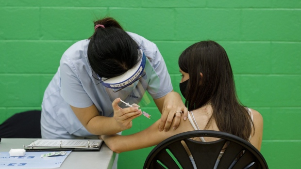 An adolescent receives a dose of the Pfizer-BioNTech Covid-19 vaccine at a clinic in Toronto, Ontario, Canada, on Wednesday, May 19, 2021. Canada is the second country to allow use of the Pfizer vaccine for adolescents, after Algeria. Photographer: Cole Burston/Bloomberg