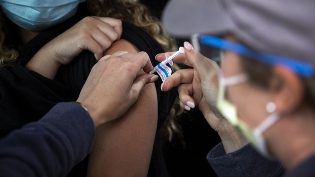 A healthcare worker administers a dose of the Pfizer-BioNTech Covid-19 vaccine to a teenager at the Oregon Health & Science University (OHSU) mass vaccination site at Portland International Airport (PDX) in Portland, Oregon, U.S., on Monday, May 17, 2021. The U.S. on Sunday recorded its lowest number of new coronavirus infections since the early days of the pandemic. Photographer: Alisha Jucevic/Bloomberg