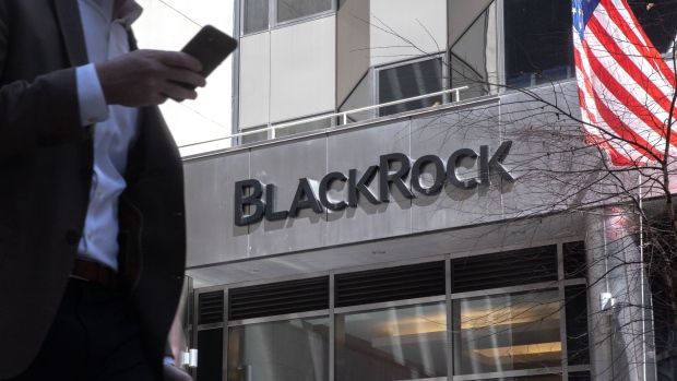 A pedestrian holding a smartphone passes in front of BlackRock Inc. headquarters in New York, U.S, on Tuesday, April 13, 2021. BlackRock Inc. is scheduled to release earnings figures on April 15.