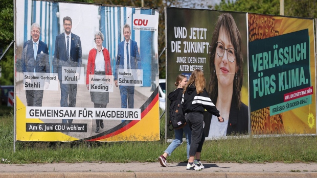 People walk past election campaign posters of the German Christian Democrats (CDU), the German Social Democrats (SPD) and the German Greens on May 28, 2021 in Magdeburg, Germany.