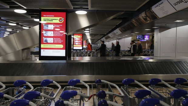 An electronic board displays government-issued coronavirus advice by an empty baggage reclaim belt inside the arrivals terminal at Geneva International Airport on March 13.