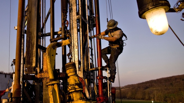 Nomac Drilling Corp. derrick man Justin Spruell, right, climbs down from an overhead platform after connecting a section of drill pipe on a Chesapeake Energy Corp. natural gas drill site in Bradford County, Pennsylvania.
