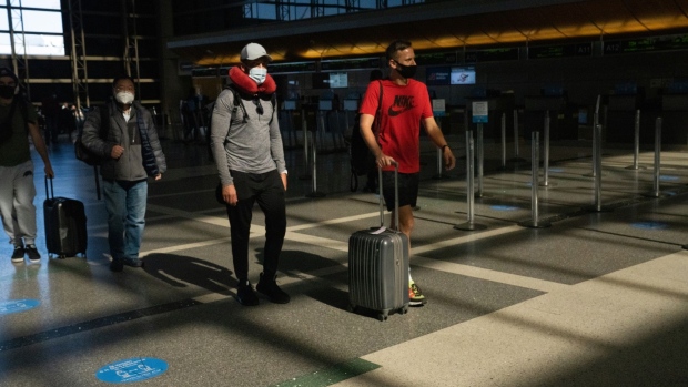 Travelers wearing protective masks inside Tom Bradley International Terminal (Terminal B) at Los Angeles International Airport (LAX) in Los Angeles, California, U.S., on Friday, May 28, 2021. The days of bargain basement airfares are ending as the U.S. vaccine supply unleashes a wave of pent-up travel demand. Photographer: Bing Guan/Bloomberg