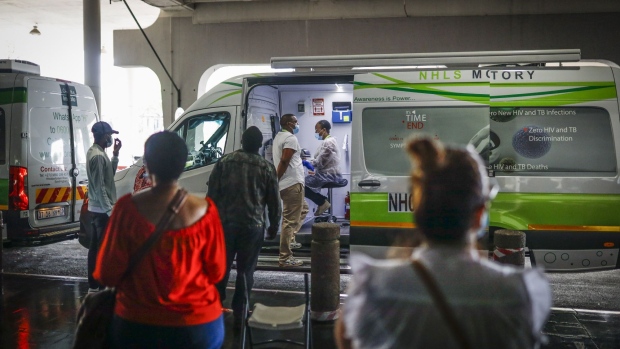 Passengers queue to be tested by medical staff at a South Africa Health Department mobile coronavirus testing unit outside O.R Tambo International Airport in Johannesburg, South Africa, on Tuesday, Jan. 5, 2020. South Africa's government has drawn criticism over its Covid-19 vaccine rollout plan, with unions and medical groups among those to have expressed concern about the sluggishness of the state’s response amid a resurgence in cases, hospitalizations and deaths. Photographer: Guillem Sartorio/Bloomberg