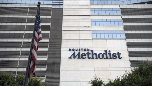 An American flag flies outside the Houston Methodist Hospital at the Texas Medical Center (TMC) campus in Houston, Texas, U.S., on Wednesday, June 24, 2020. Harris County, which encompasses Houston, projects that ICU beds will be full in 11 days at the current pace of infections, according to county data. Photographer: Callaghan O'Hare/Bloomberg