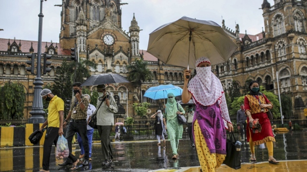 Pedestrians wearing protective masks cross a road outside Chhatrapati Shivaji Maharaj Terminus (CST) railway station during the morning rush hour in Mumbai, India, on Tuesday, July 14, 2020. With India now one of the world's top three Covid-19 hotspots, the country is focused on controlling its pandemic and reviving stalled economic growth, Prime Minister Narendra Modi said last Thursday. Photographer: Dhiraj Singh/Bloomberg