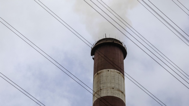 Smoke rises from a chimney as electricity pylons stand at the Tata Power Co. Trombay Thermal Power Station in Mumbai, India, on Saturday, Aug. 5, 2017. Nearly six months after his turbulent elevation to run India's biggest conglomerate, Tata Chairman Natarajan Chandrasekaran is assembling a team of dealmakers to refocus some of the group’s biggest businesses, expand its financial services and consumer businesses and sell or merge dozens of smaller units, according to interviews with senior executives. Photographer: Dhiraj Singh/Bloomberg