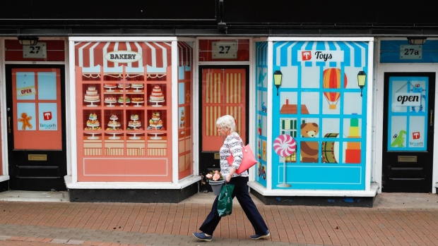 A woman walks past a closed store with a false frontage on Market Street in Tamworth, U.K., on Wednesday, May 26, 2021. Tamworth will benefit from the U.K. government's Future High Streets fund to boost infrastructure and redevelop underused properties.