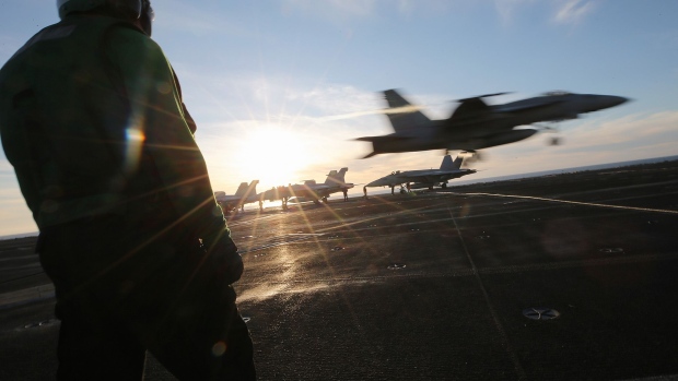 A U.S. Navy sailor maintenance worker (L) keeps watch on the flight deck during flight operations aboard the USS Nimitz (CVN 68) aircraft carrier, while at sea, on January 18, 2020 off the coast of Baja California, Mexico. 