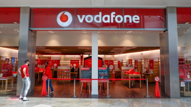 A member of the public awaits entry to a Vodafone Group Plc mobile phone store in Reading, U.K.