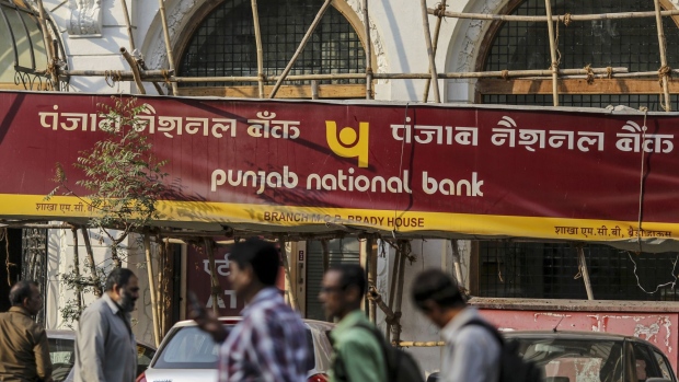 Pedestrians walk past a Punjab National Bank (PNB) branch in Mumbai, India, on Wednesday, Feb. 14, 2018. PNB, one of India's biggest banks, has accused jeweler�Nirav Modi�-- who's dressed stars including Kate Winslet and Priyanka Chopra -- of involvement in a multi-billion dollar fraud that could extend to other lenders, said people familiar with the matter. Photographer: Dhiraj Singh/Bloomberg