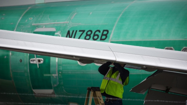 An employee works on the wing of a 737 Max 8 plane destined for China Southern Airlines at the Boeing Co. manufacturing facility in Renton, Washington, U.S., on Tuesday, Mar. 12, 2019. The Boeing 737 Max crash in Ethiopia looks increasingly likely to hit the planemaker's order book as mounting safety concerns prompt airlines to reconsider purchases worth about $55 billion. Photographer: David Ryder/Bloomberg