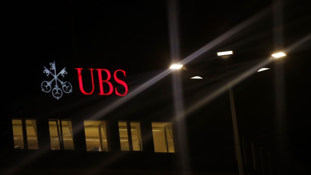 An illuminated company logo is displayed at a UBS Group AG bank branch in Zurich. Photographer: Stefan Wermuth/Bloomberg