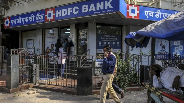 Pedestrian walk past an HDFC Bank Ltd. branch in Mumbai, India, on Friday, Dec. 4, 2020. Home sales in India's commercial capital jumped to an eight year high in October, according to data from Knight Frank, marking an abrupt turnaround for a market that's spent three years in the doldrums after a prolonged shadow banking crisis strangled access to credit. Photographer: Dhiraj Singh/Bloomberg