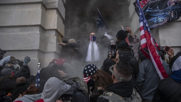 Demonstrators attempt to breach the U.S. Capitol after they earlier stormed the building in Washington, DC, U.S., on Wednesday, Jan. 6, 2021. The U.S. Capitol was placed under lockdown and Vice President Mike Pence left the floor of Congress as hundreds of protesters swarmed past barricades surrounding the building where lawmakers were debating Joe Biden's victory in the Electoral College.